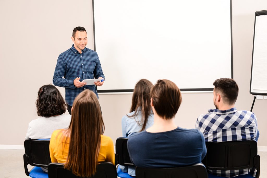 young business man manager on meeting in a conference room speaking in front of company staff or students -